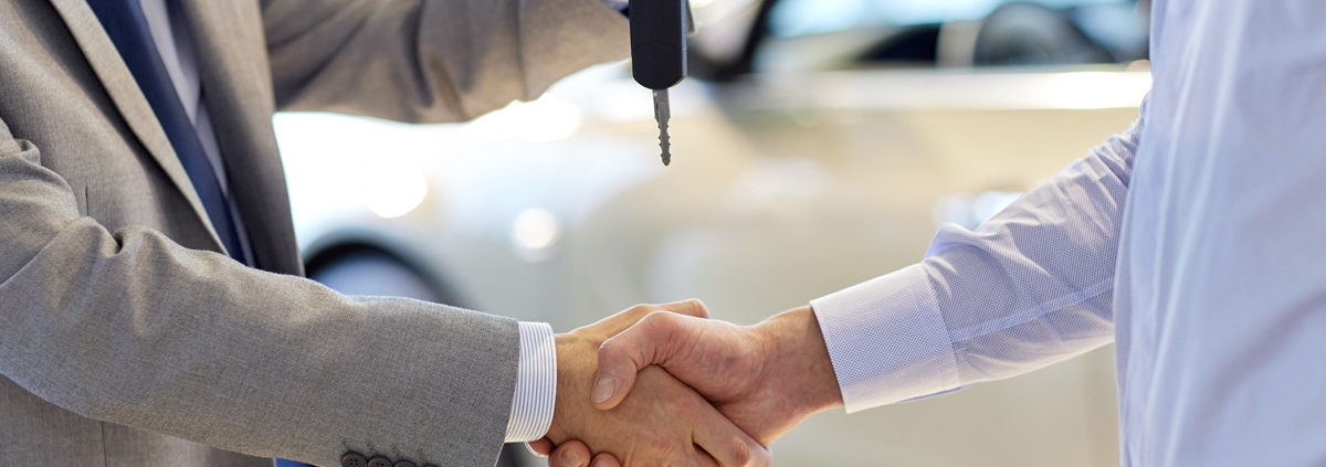 Man handing car keys to another man